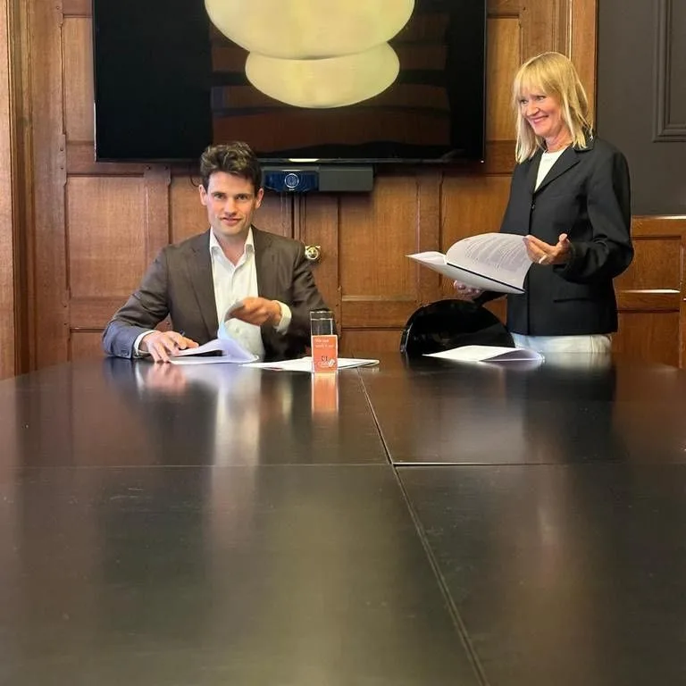 Twee juridische professionals in vergaderruimte met dossiers en documenten