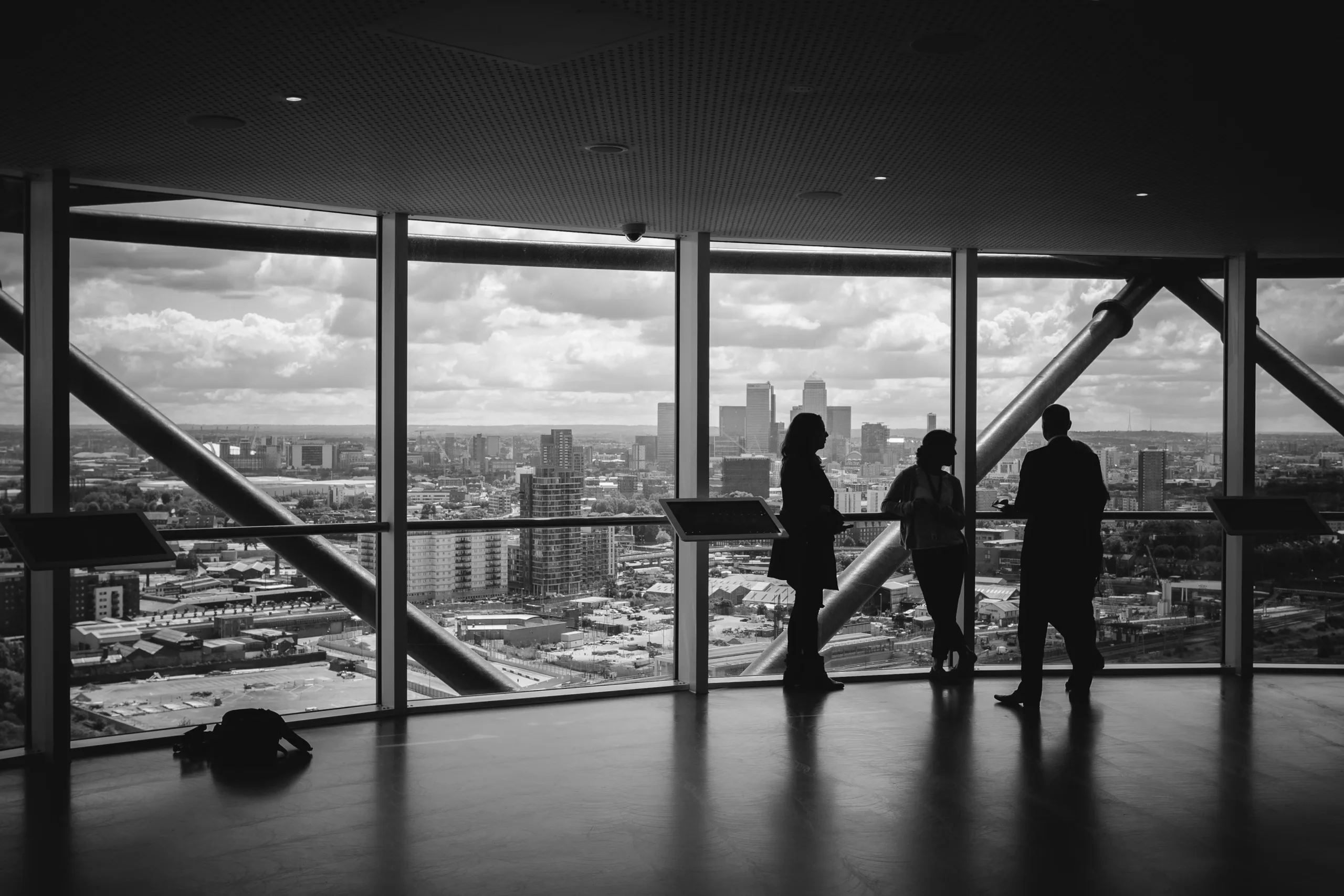Silhouetten van zakelijke professionals voor groot raam met uitzicht over de stad